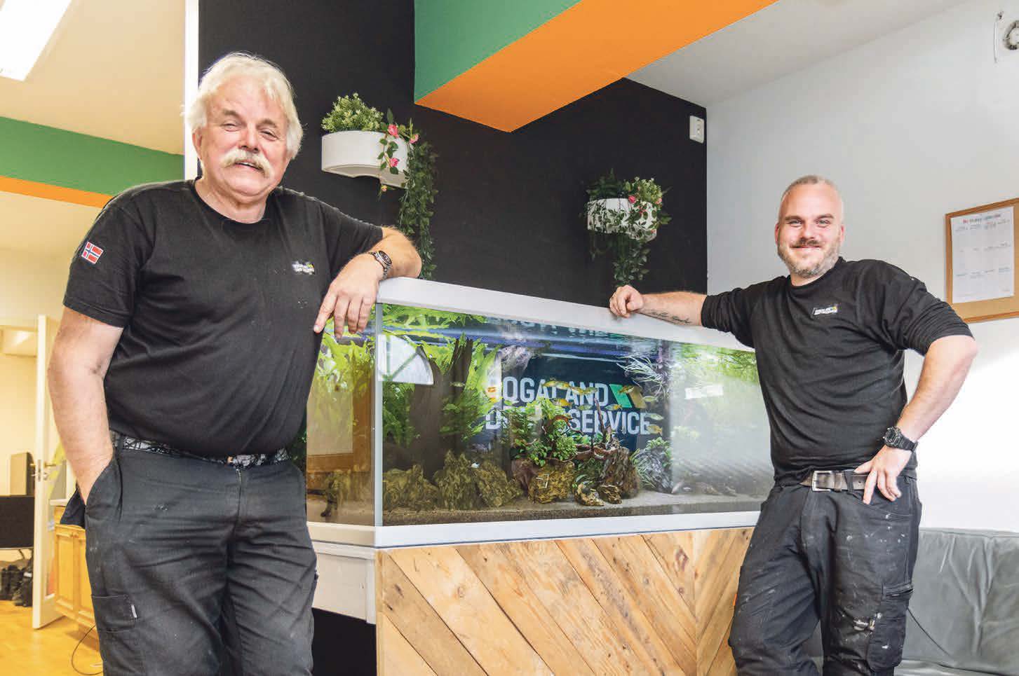 FAR OG SØNN: Det store akvariet er det en av de ansatte som har ansvar for, til glede for Hans Woldmo (til venstre) og daglig leder Jone Woldmo - og alle de andre som stikker innom kontoret.